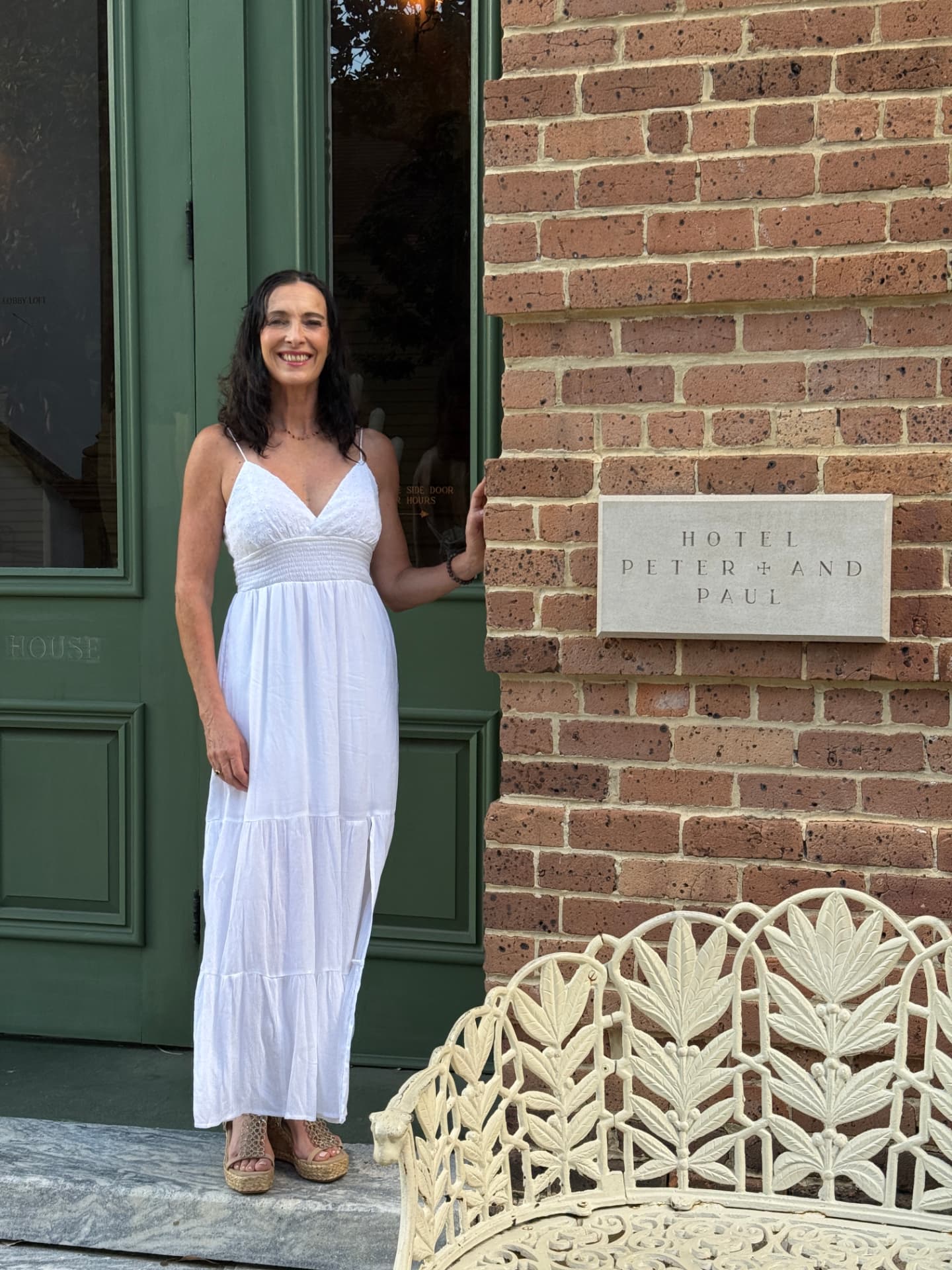 Niamh, founder of Become, standing in a deep green doorway